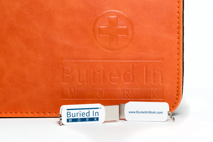 An orange CLEAR Kit binder with two branded USB drives