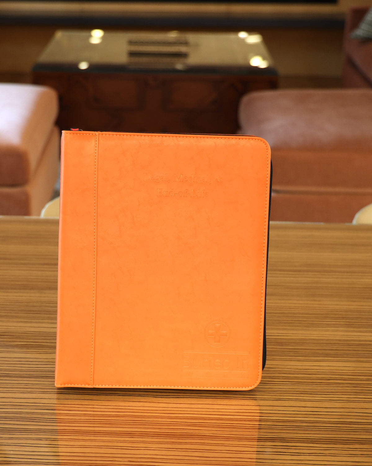 The orange CLEAR Kit Essentials binder standing on a table
