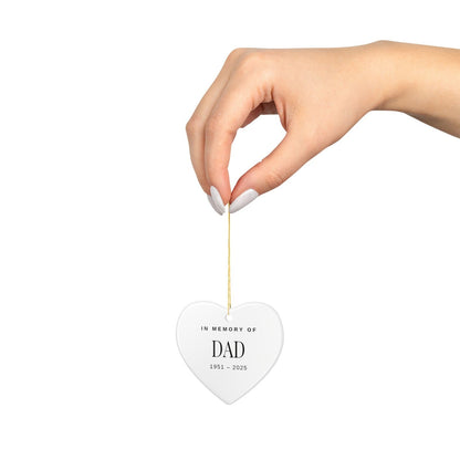 The heart ornament hanging from its gold string, shown at actual size in a hand